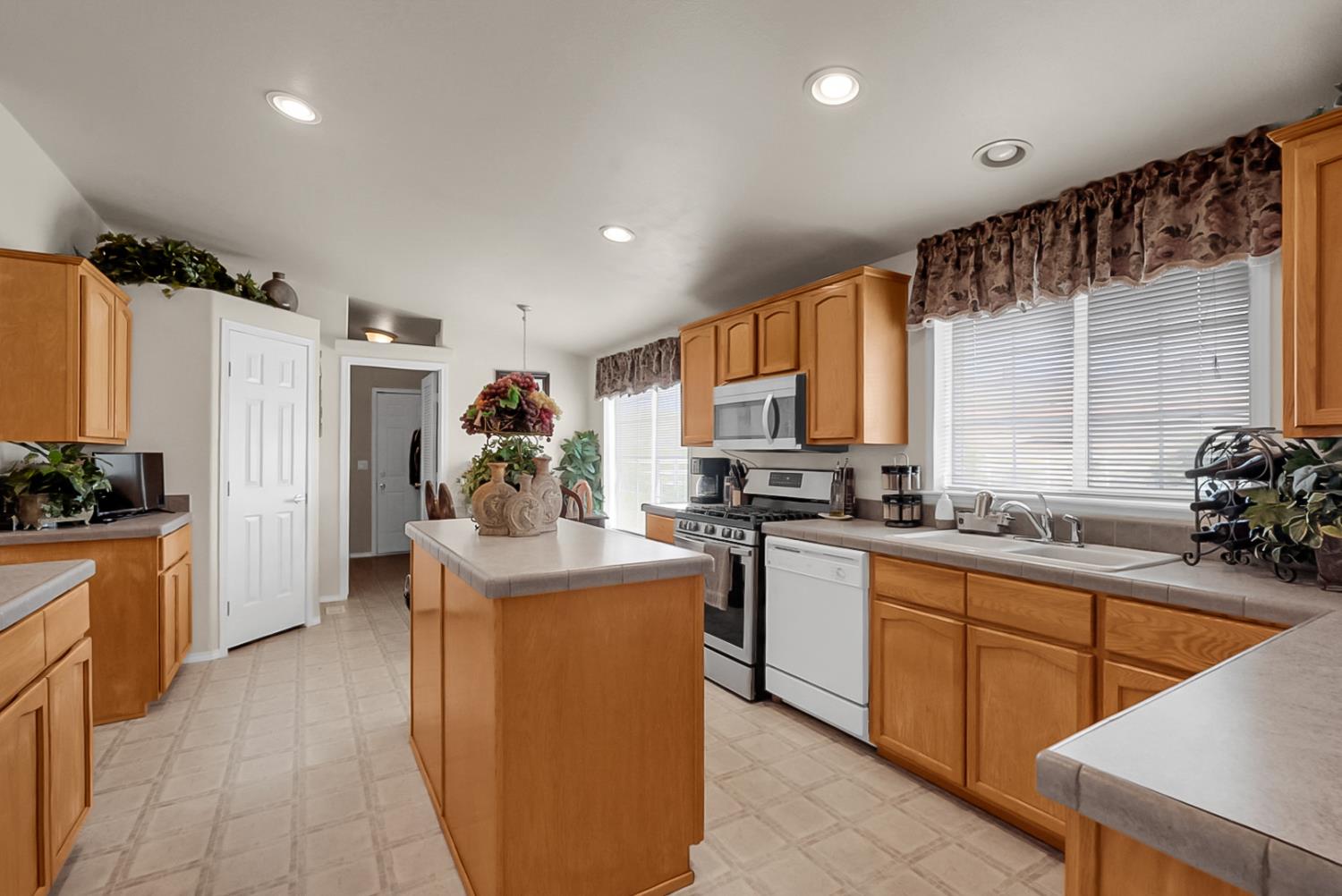 19814 West Grant Line Road Tracy, CA 95391 - Photo 6 of 57 a kitchen with stainless steel appliances granite countertop a sink counter space cabinets and a window