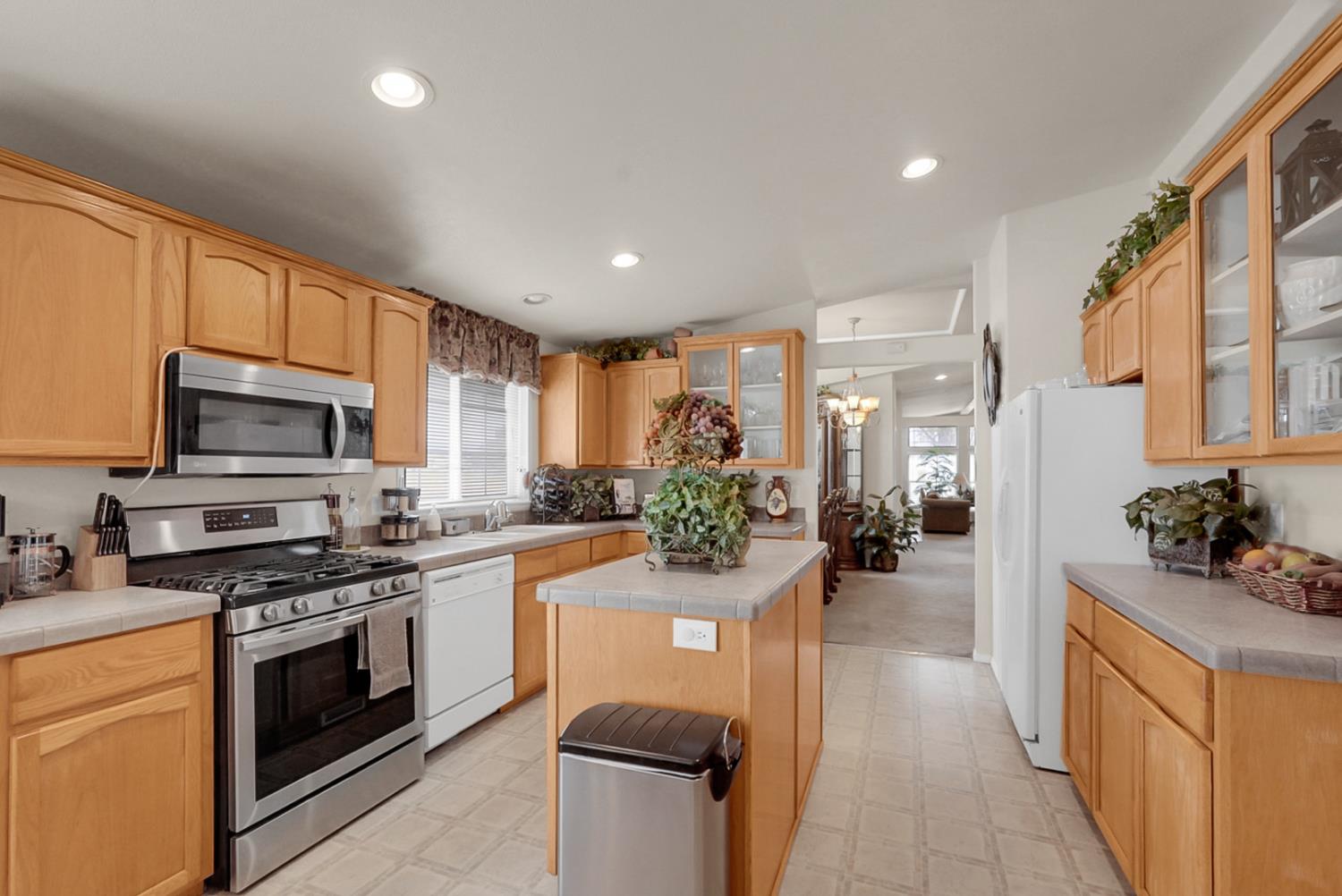 19814 West Grant Line Road Tracy, CA 95391 - Photo 7 of 57 a kitchen with stainless steel appliances a stove sink microwave and cabinets