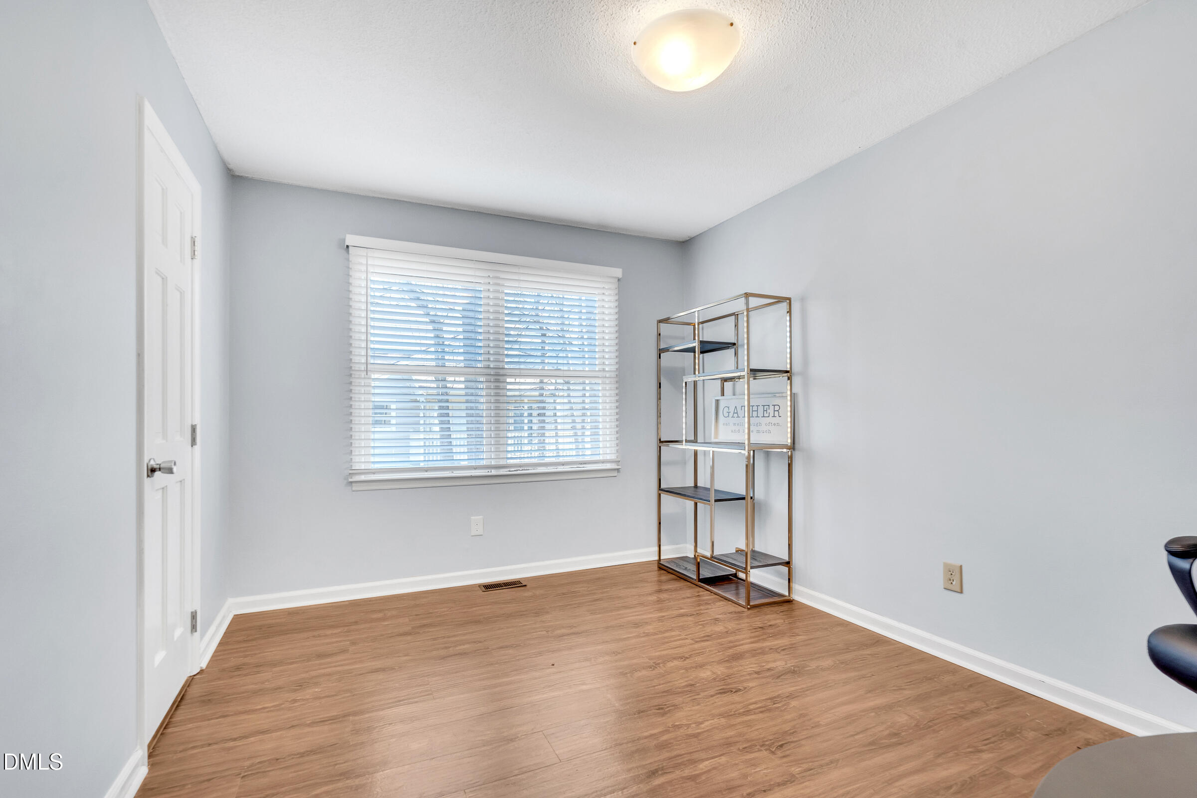 6410 English Oaks Drive Raleigh, NC 27615 - Photo 15 of 19 an empty room with wooden floor and windows