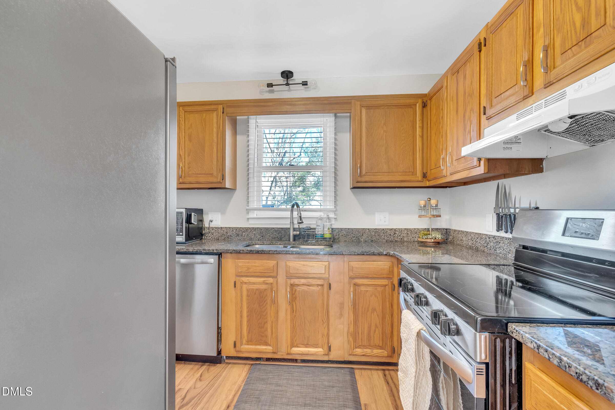 6410 English Oaks Drive Raleigh, NC 27615 - Photo 6 of 19 a kitchen with stainless steel appliances granite countertop a sink stove and cabinets