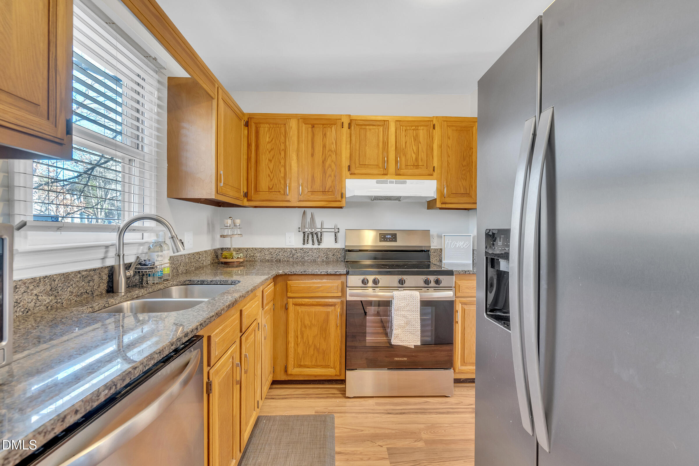 6410 English Oaks Drive Raleigh, NC 27615 - Photo 7 of 19 a kitchen with stainless steel appliances granite countertop a sink a stove and a refrigerator