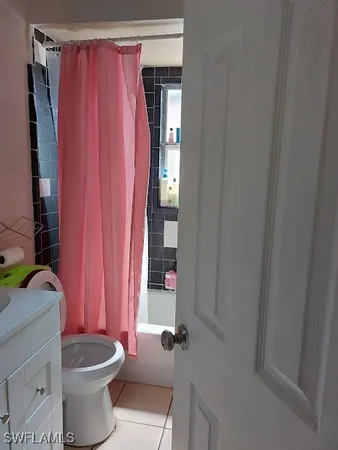 a bathroom with a sink a toilet and shower curtain