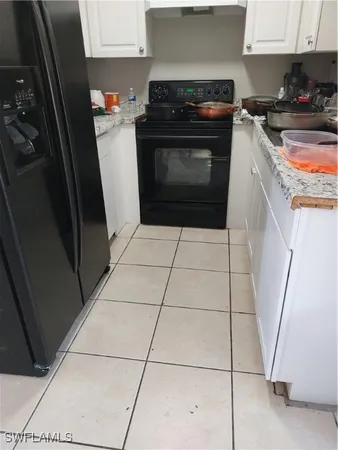 a kitchen with granite countertop a sink a stove and cabinets