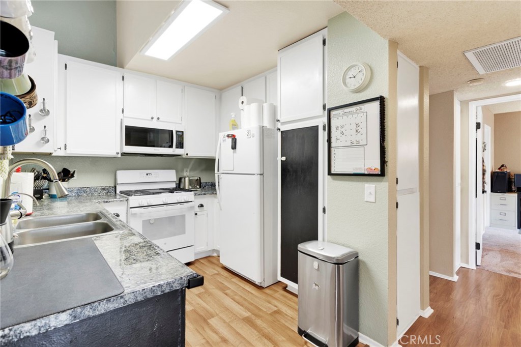 8423 Western Trail Place, Unit H Rancho Cucamonga, CA 91730 - Photo 16 of 42 a kitchen with stainless steel appliances granite countertop a refrigerator sink and microwave