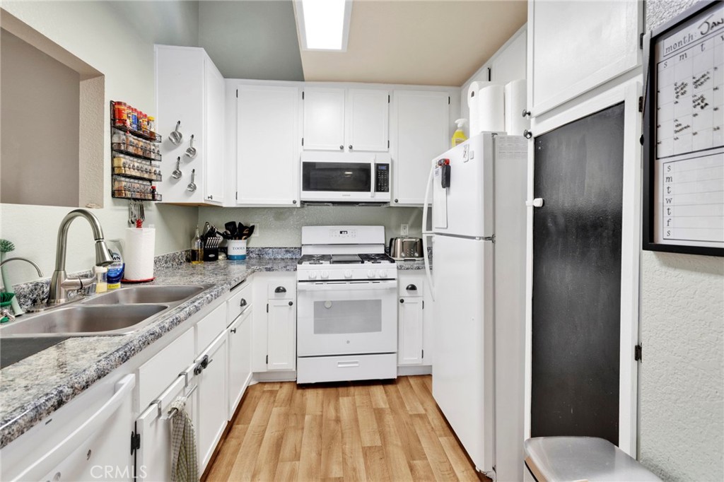 8423 Western Trail Place, Unit H Rancho Cucamonga, CA 91730 - Photo 17 of 42 a kitchen with white cabinets sink and stainless steel appliances