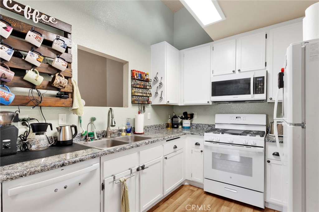 8423 Western Trail Place, Unit H Rancho Cucamonga, CA 91730 - Photo 18 of 42 a kitchen with appliances a sink and cabinets