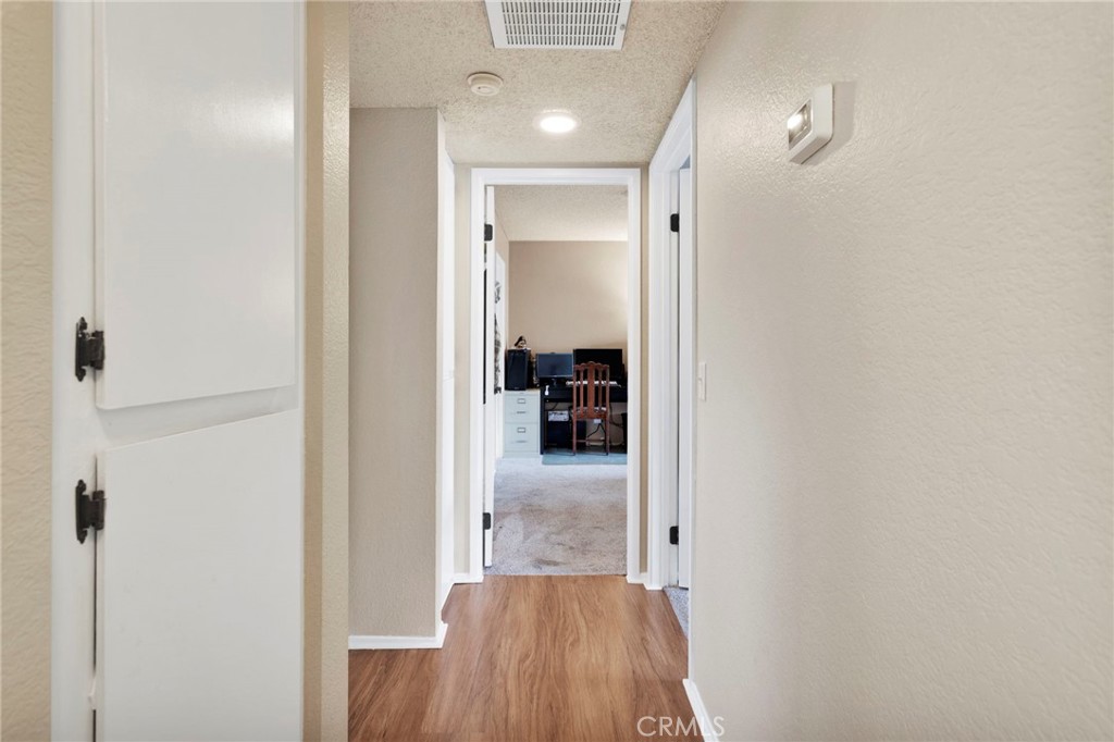 8423 Western Trail Place, Unit H Rancho Cucamonga, CA 91730 - Photo 19 of 42 a view of a hallway with wooden floor