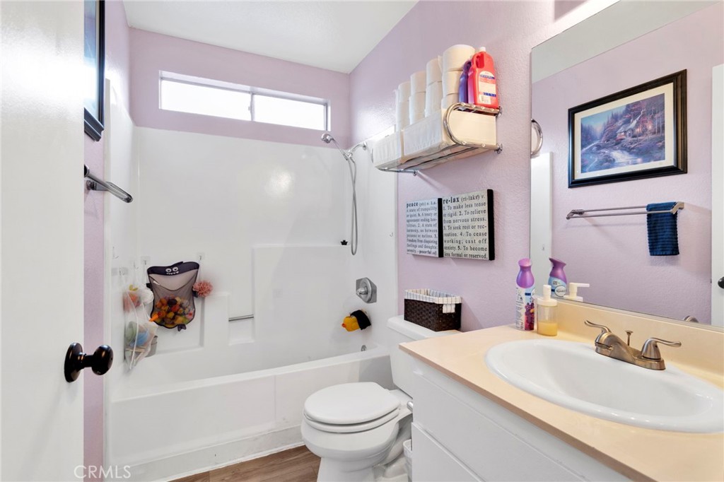8423 Western Trail Place, Unit H Rancho Cucamonga, CA 91730 - Photo 27 of 42 a bathroom with a sink a toilet a mirror a vanity a window and shower