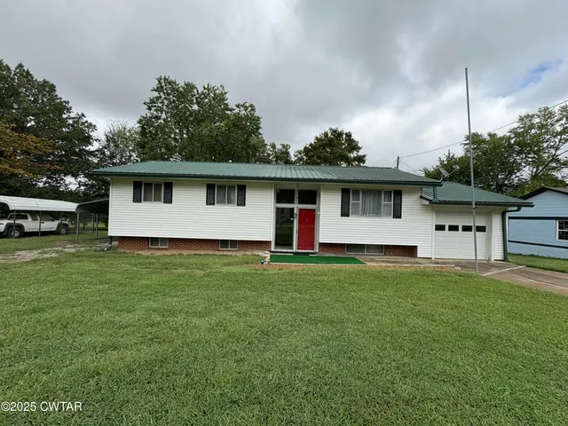 a front view of house with yard and trees