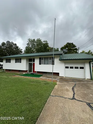 a front view of a house with a garden and yard