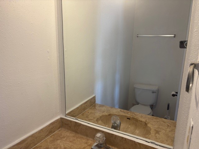 6702 Everhart Road, Unit H103 Corpus Christi, TX 78413 - Photo 7 of 14 a bathroom with a sink and toilet