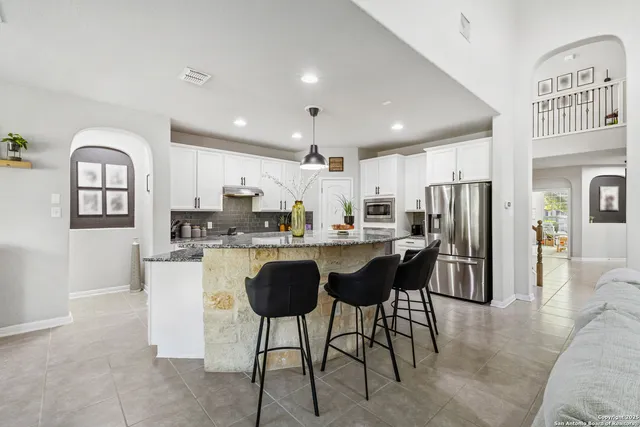 a kitchen with stainless steel appliances granite countertop a refrigerator and a sink