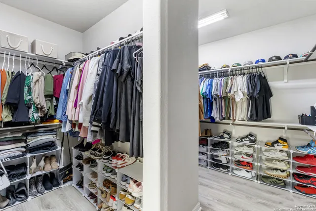 a view of walk in closet with clothes and shoes