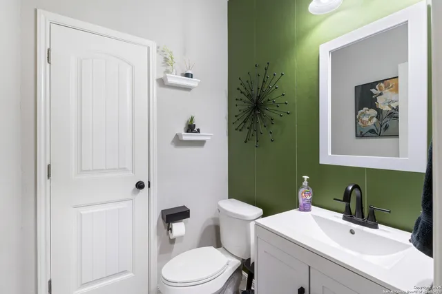 a bathroom with a toilet a sink and mirror