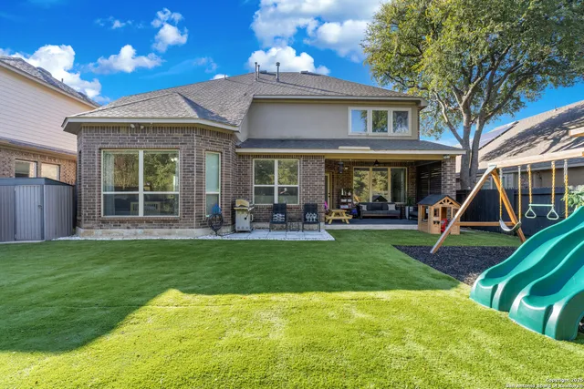 a view of a house with a yard patio and a slide