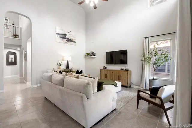a living room with furniture a flat screen tv and a window