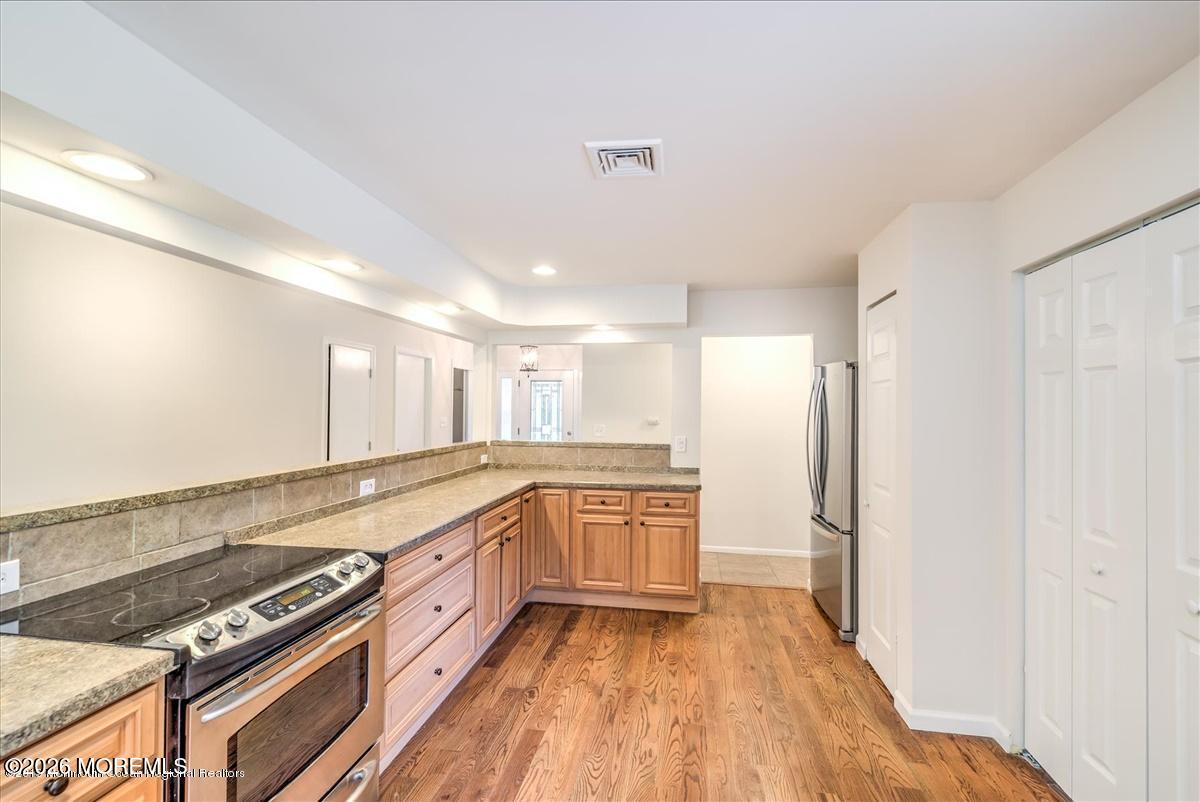 699 Aldrich Road Howell, NJ 07731 - Photo 11 of 23 a large kitchen with stainless steel appliances granite countertop a stove and a refrigerator