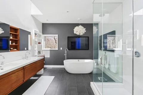 a spacious bathroom with a tub sink and mirror