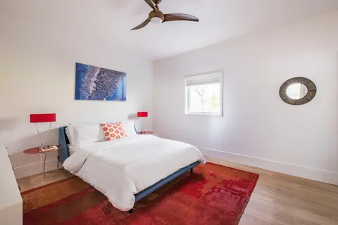 a bedroom with a bed and a wooden floor