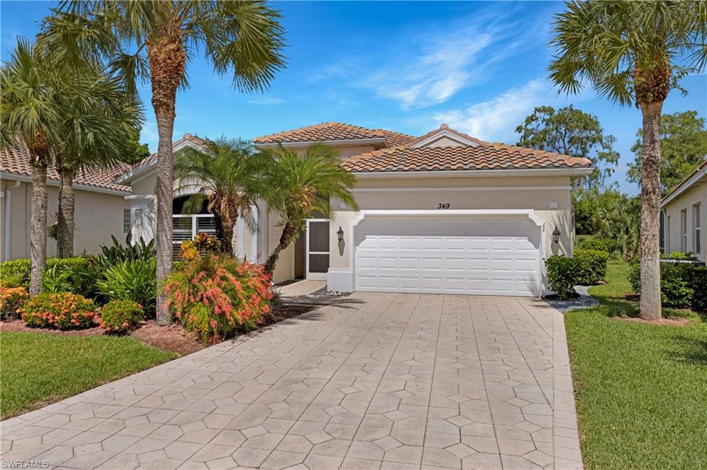 349 Harvard Lane Naples, FL 34104 - Photo 1 of 29 a front view of a house with a yard and potted plants