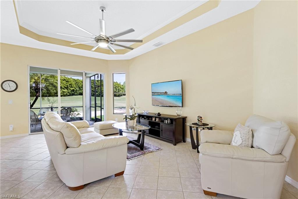 349 Harvard Lane Naples, FL 34104 - Photo 6 of 29 a living room with furniture a flat screen tv and a large window