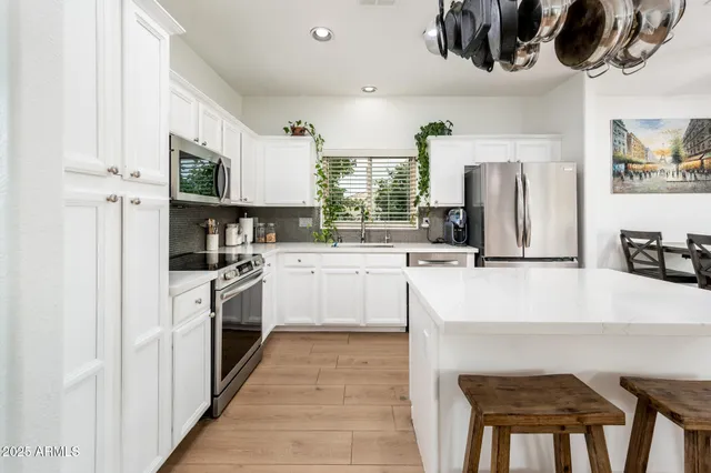a kitchen with stainless steel appliances a stove a sink and a refrigerator