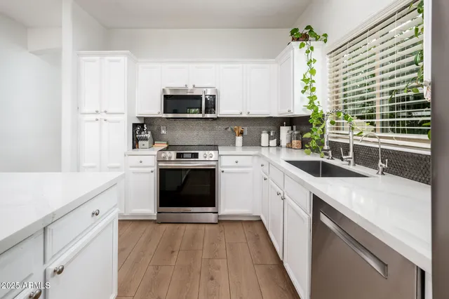 a kitchen with a sink a stove and cabinets