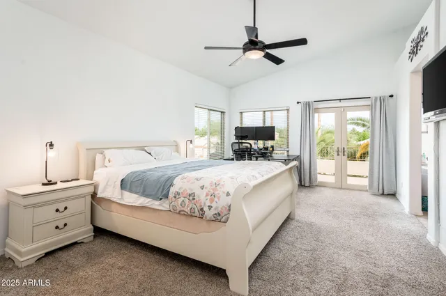 a spacious bedroom with a bed and a ceiling fan