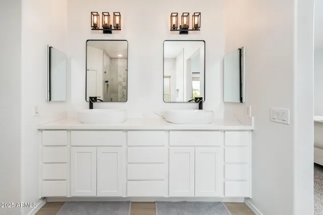 a bathroom with double vanity sink and a mirror