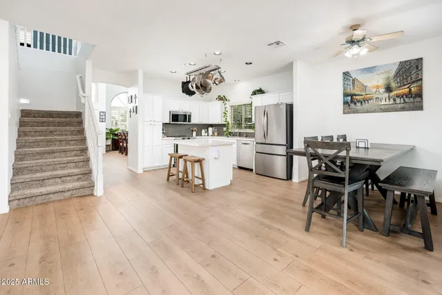 a living room with stainless steel appliances kitchen island granite countertop furniture and a wooden floor