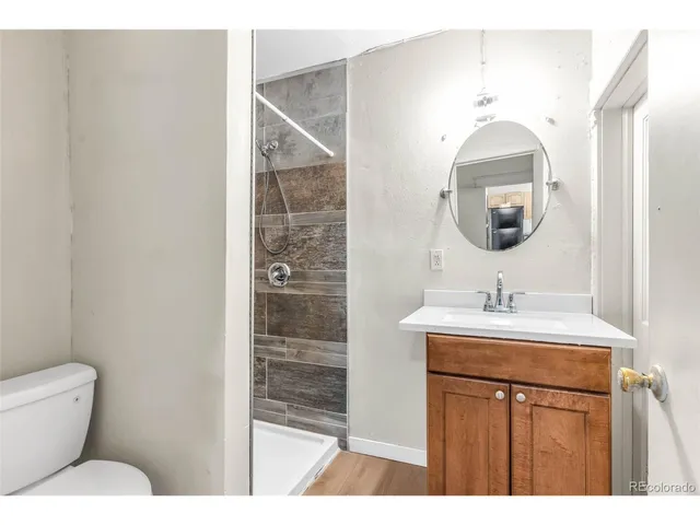 a bathroom with a toilet a sink and mirror