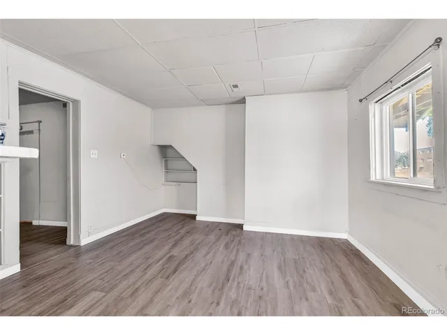 a view of an empty room with wooden floor