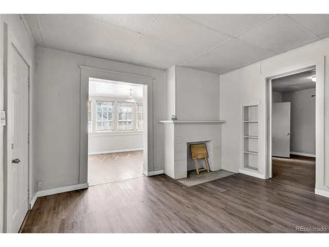 a view of an empty room with a fireplace and a window