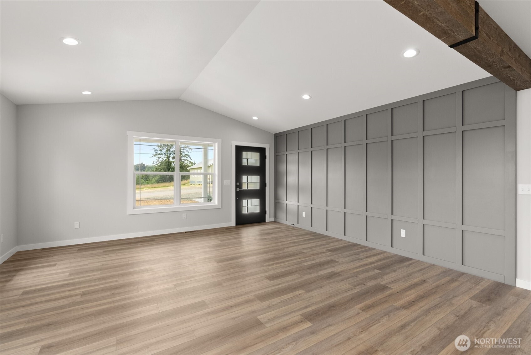 635 Elm Street Raymond, WA 98577 - Photo 4 of 20 a view of an empty room with a window and wooden floor