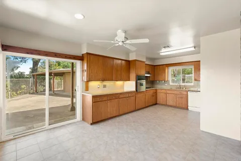 a large kitchen with a sink and dishwasher a oven with white cabinets