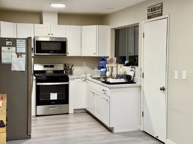 a kitchen with stainless steel appliances a stove a microwave and cabinets