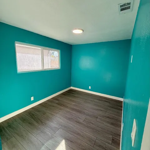 a view of empty room with window and hardwood