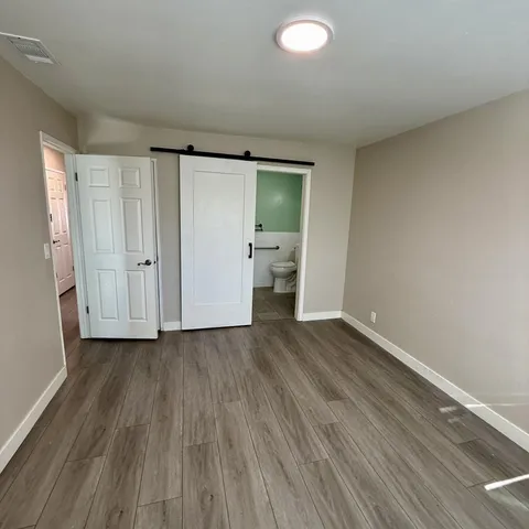 a view of empty room with wooden floor