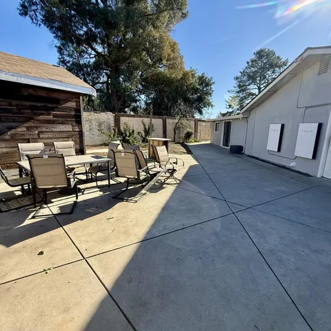 a view of a patio with table and chairs with wooden fence