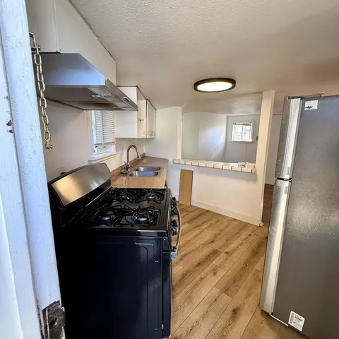 a kitchen with granite countertop a stove and a refrigerator