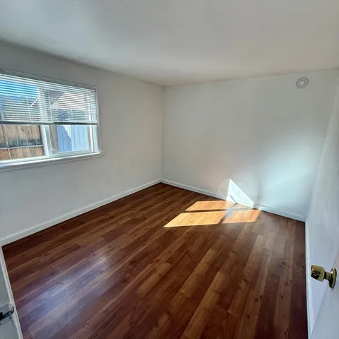 a room with a bed and wooden floor