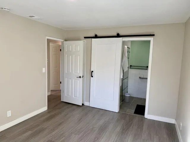 an empty room with wooden floor and closet