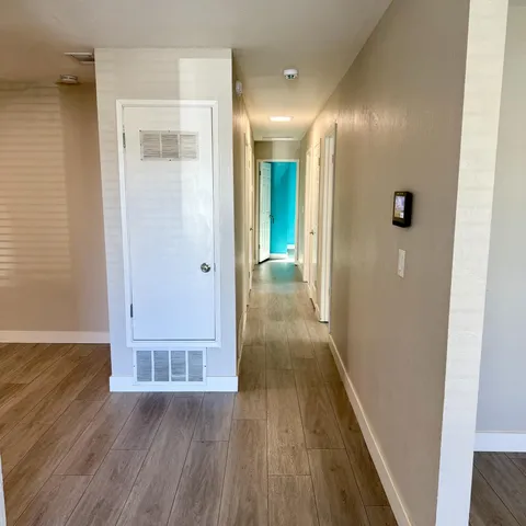 a view of a hallway with wooden floor