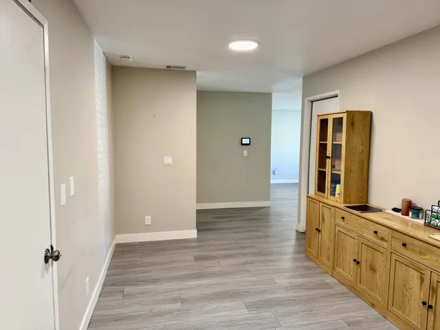an empty room with wooden floor and white walls