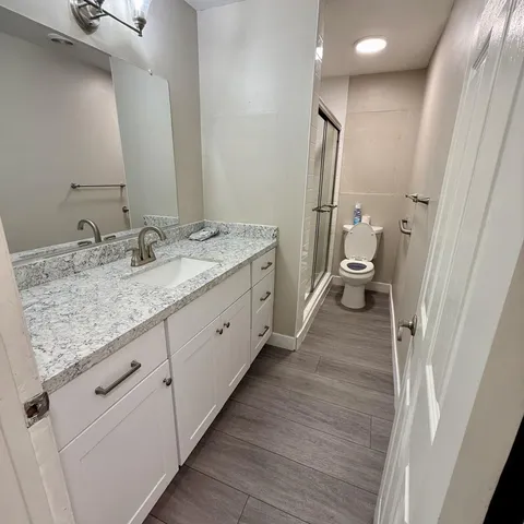 a spacious bathroom with a granite countertop sink and a mirror