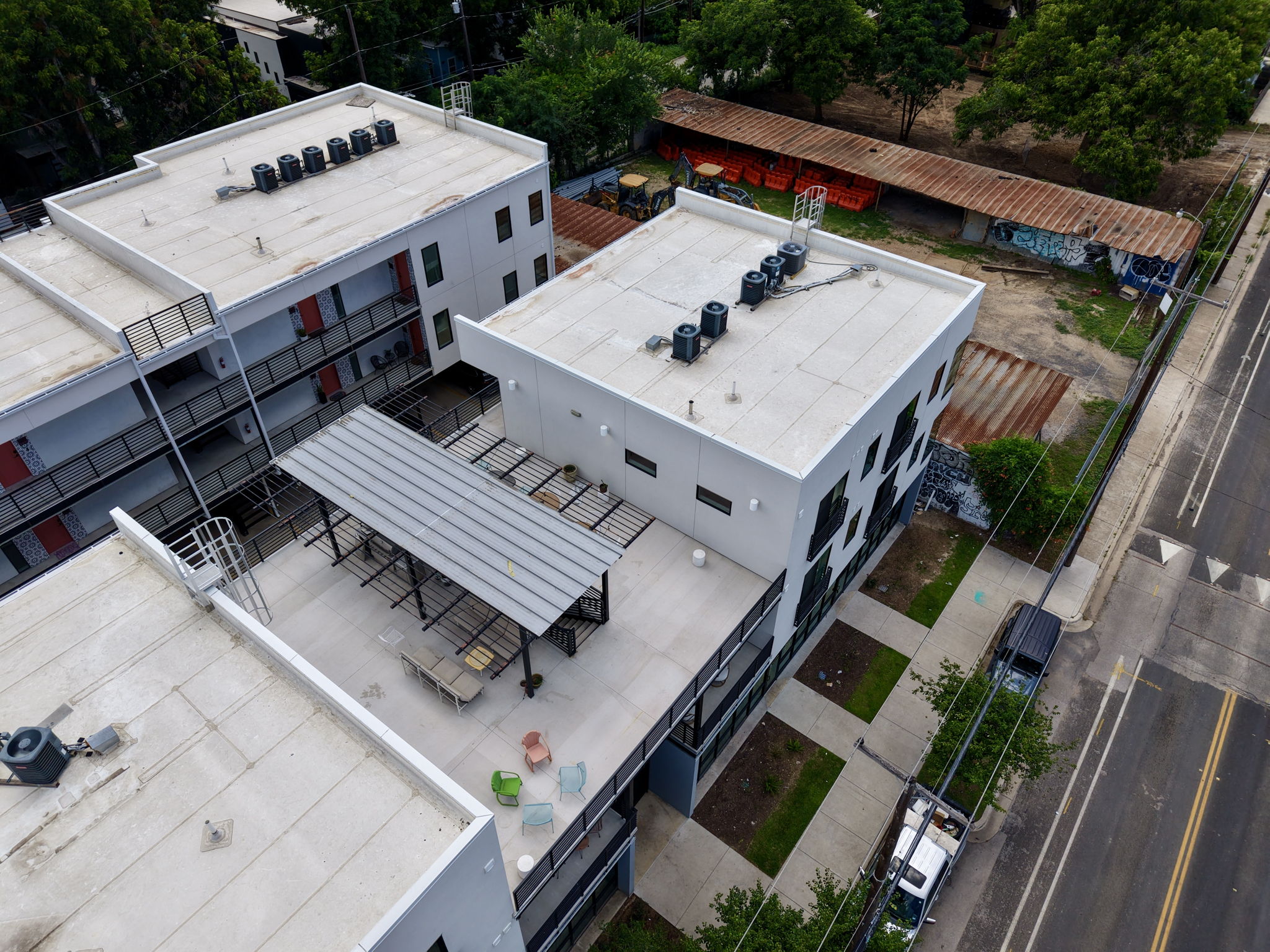 2709 East 5th Street, Unit 1306 Austin, TX 78702 - Photo 25 of 28 Aerial view showcasing modern urban residential buildings with rooftop amenities and surrounding streetscape.