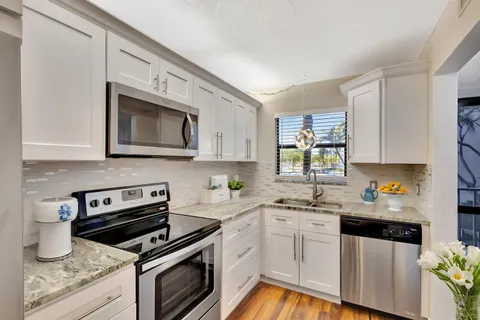 a kitchen with stainless steel appliances a stove sink microwave and cabinets
