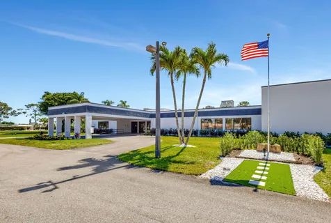 a front view of a house with a garden and patio