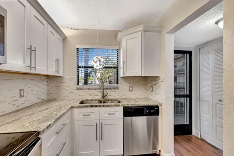 a kitchen with stainless steel appliances granite countertop a sink stove and cabinets