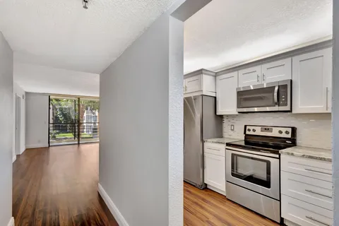 a kitchen with wooden floors and stainless steel appliances